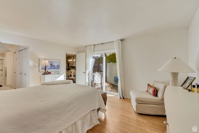 Bedroom featuring light wood finished floors, baseboards, an inviting chandelier, and access to exterior | Image 15