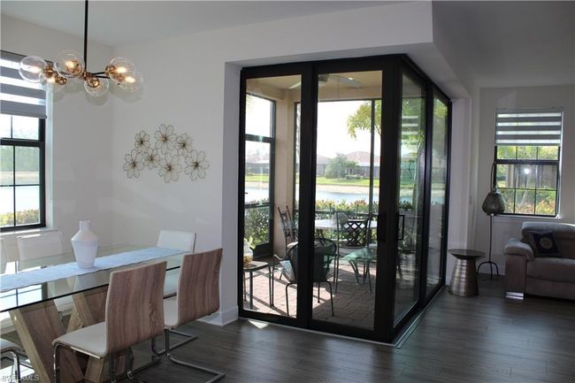 Doorway featuring a wealth of natural light, a notable chandelier, and dark wood-type flooring | Image 12