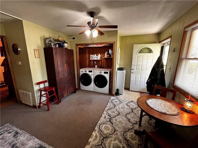 Laundry room featuring washer and dryer, a ceiling fan, and carpet | Image 9