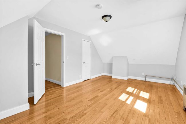 Additional living space with baseboards, light wood-style flooring, and lofted ceiling | Image 8