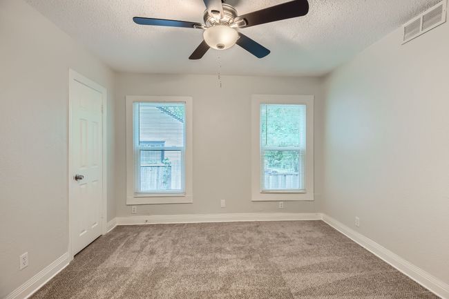 Carpeted spare room featuring a textured ceiling, visible vents, and a wealth of natural light | Image 23
