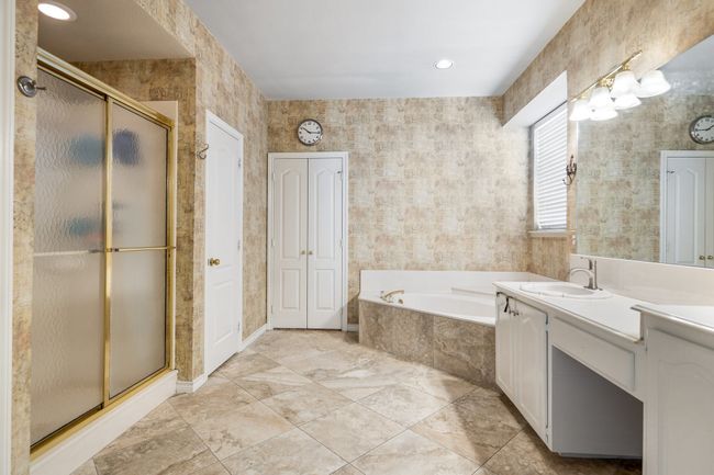 Full bath with a bath, baseboards, vanity, and a stall shower | Image 16