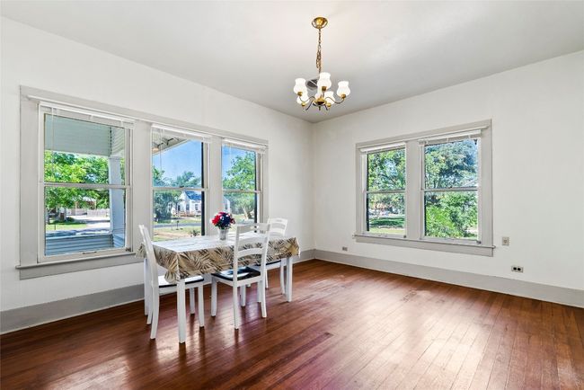 Dining area with a chandelier, healthy amount of natural light & wood flooring | Image 8
