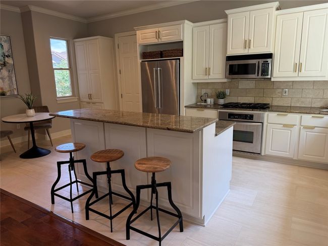 Kitchen featuring a kitchen breakfast bar, granite, White cabinets and stainless steel appliances (refrigerator can convey) | Image 14