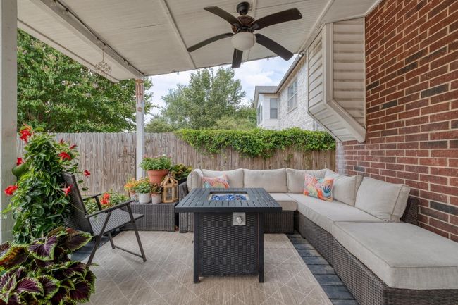 Fenced backyard featuring an outdoor living space with a fire pit, a ceiling fan, and a patio area | Image 30