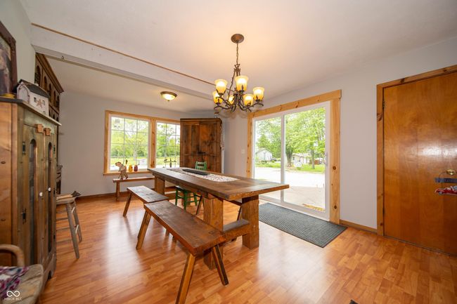 dining room featuring a chandelier, light wood finished floors, and baseboards | Image 15