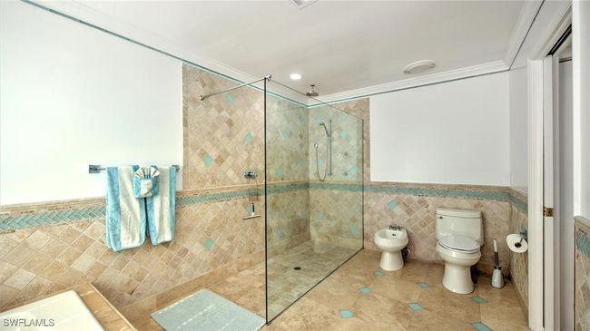 Master bath featuring tile walls, a wainscoted wall, a walk in shower, a bidet, and tile patterned floors | Image 19