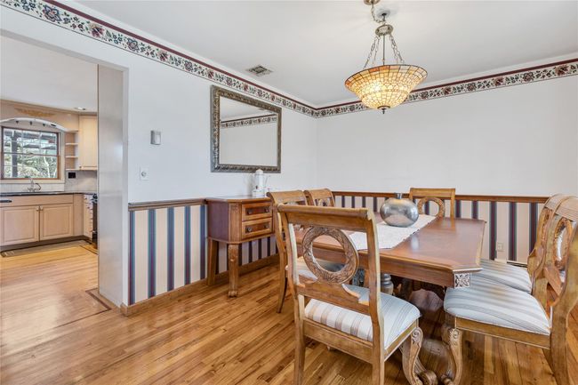 Dining area featuring light wood finished floors and visible vents | Image 6