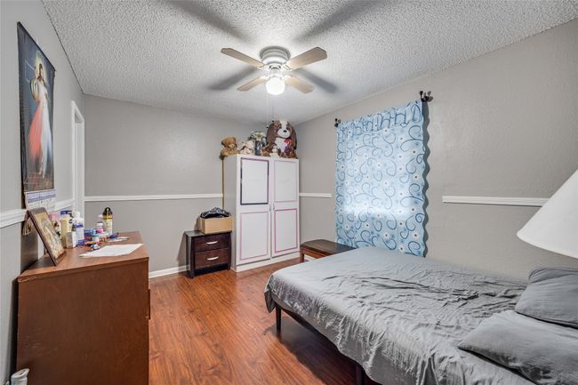 Unit B Bedroom with a textured ceiling, ceiling fan, and dark hardwood / wood-style floors | Image 26