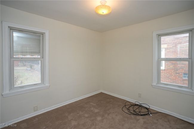 Empty room with dark colored carpet and baseboards | Image 13