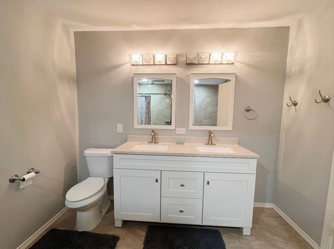 Bathroom featuring double vanity and a shower with curtain | Image 10