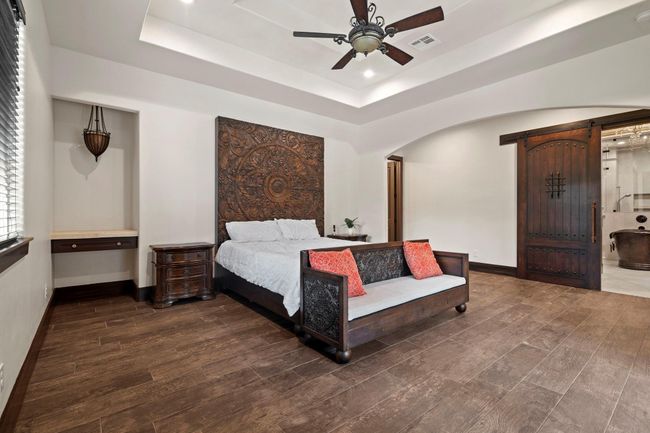 Custom wood sliding door leading into primary bath. | Image 27