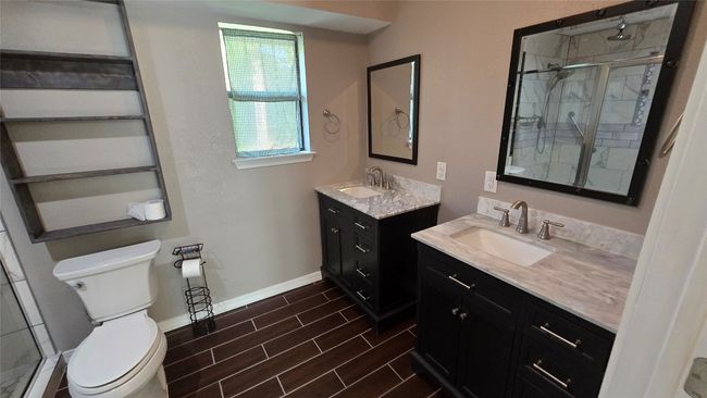 Upgraded Bathroom featuring a shower stall, two vanities, and wood finished floors | Image 10