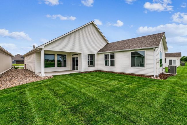 Rear view of property featuring a patio area, central air condition unit, and a lawn | Image 15