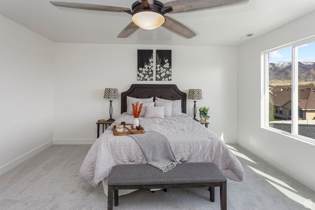 Bedroom with a ceiling fan, visible vents, light carpet, and baseboards | Image 16