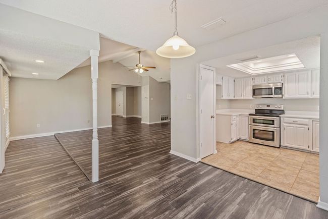 Kitchen featuring stainless steel appliances, wood finished floors, ceiling fan, baseboards, and light countertops | Image 18