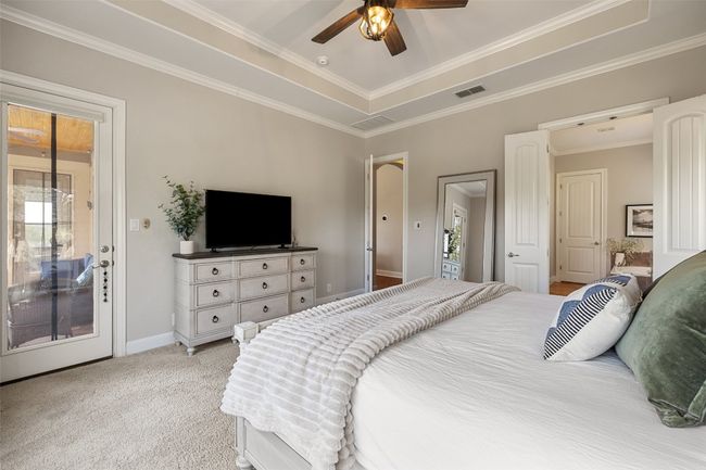 Bedroom featuring visible vents, ornamental molding, baseboards, access to outside, and light colored carpet | Image 17