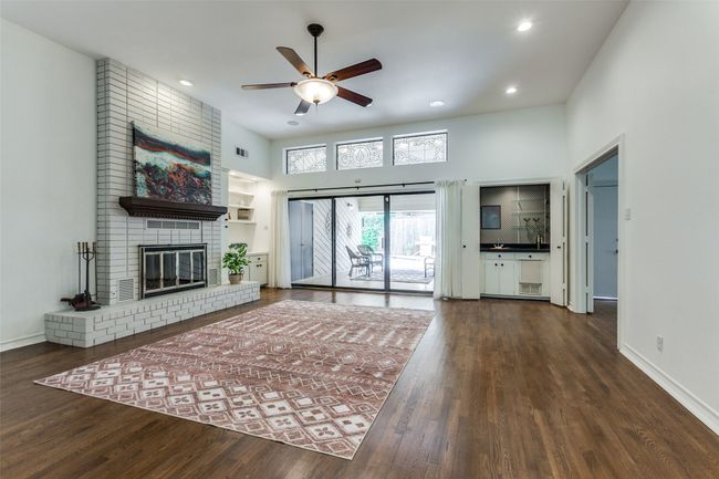 The great room is truly grand with 11' ceilings, an enormous gas fireplace and leaded glass windows above the 12' sliding glass doors. | Image 4