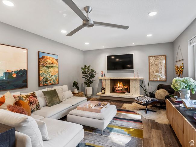 Living room with wood finished floors, a fireplace, ceiling fan, and recessed lighting | Image 9