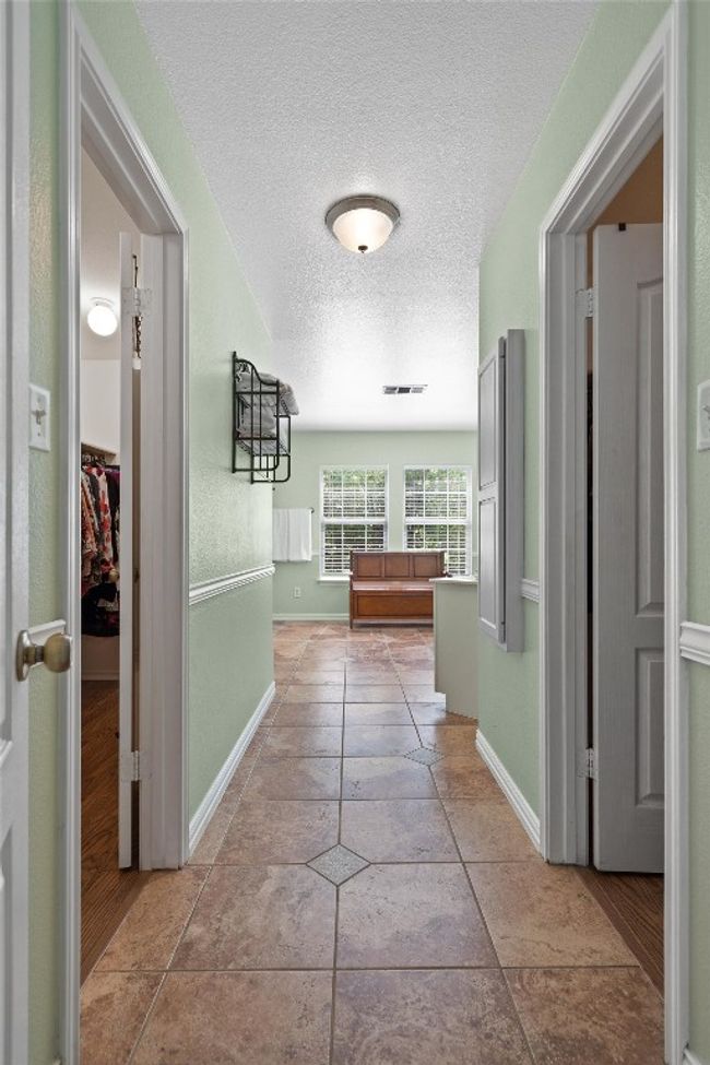 Hall with baseboards, visible vents, and a textured ceiling | Image 29