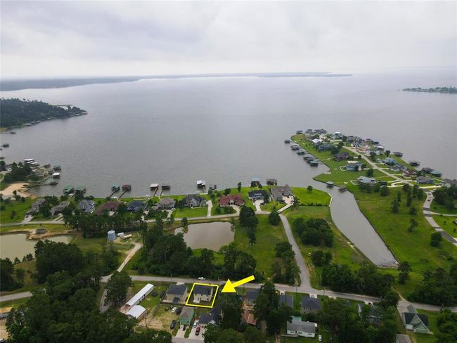 This home is water view with a green space and fishing ponds in front of the home. The pond to the left has a gazebo that you will love walking to in the evenings. One of the two community boat ramps with a fishing pier can be seen to the left middle side in this aerial view. The big water at the top is the second largest lake in the state of Texas. It is beautiful Lake Livingston! | Image 4