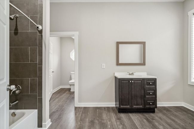 Bathroom featuring wood finished floors, toilet, vanity, bathing tub / shower combination, and baseboards | Image 27