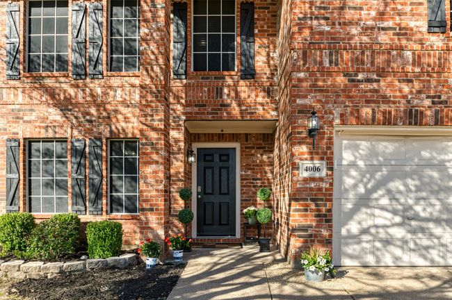 Doorway to property featuring a garage and brick siding | Image 4