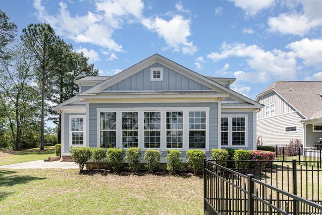 Back of house featuring board and batten siding, a lawn, and fence | Image 8