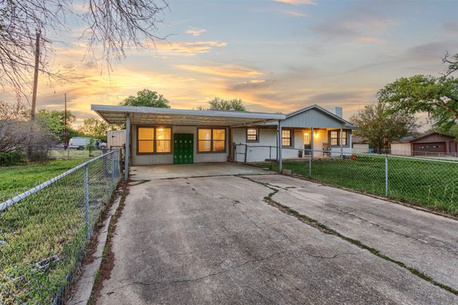 View of front facade with aphalt driveway, a porch, a yard, and a fenced front yard | Image 33
