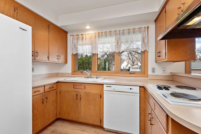 Nice kitchen with Jenn-Air cooktop for cooking and grilling, vent hood, wall oven, eat in kitchen/dining area and easy access to main floor laundry! | Image 20