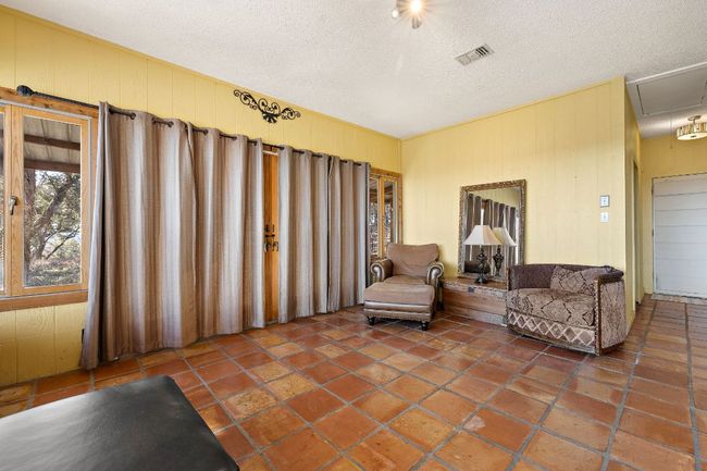 Living area with visible vents, a textured ceiling, and attic access | Image 13