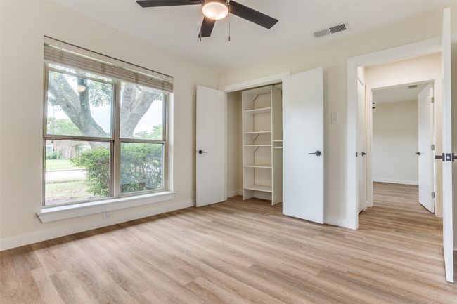 Unfurnished bedroom with light wood finished floors, baseboards, a closet, and ceiling fan | Image 14