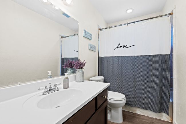 2nd Bathroom featuring toilet, vanity, shower / tub combo with curtain, and wood finished floors | Image 17