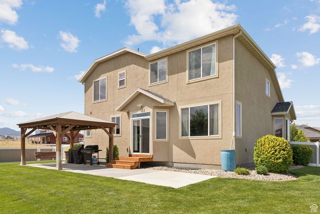 Rear view of house featuring a gazebo, stucco siding, and a patio area | Image 44