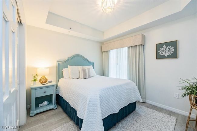 Guest Bedroom with Queen bed, tray ceiling and wood-style flooring | Image 17