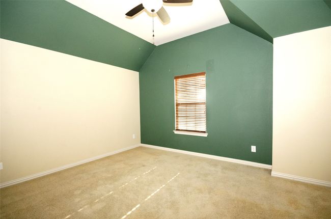 Unfurnished room with ceiling fan, carpet flooring, lofted ceiling, and baseboards | Image 19