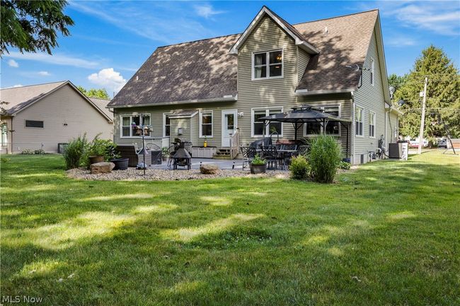 Back of property with a patio, a yard, central air condition unit, and a gazebo | Image 43