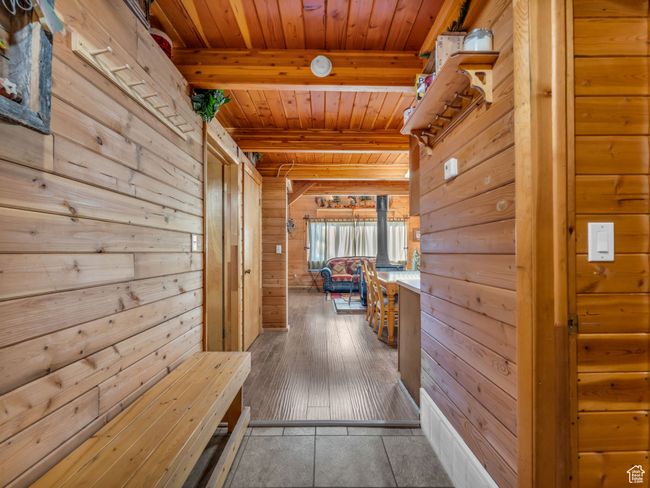 Hall featuring a wooden ceiling with exposed beams and wood walls | Image 13