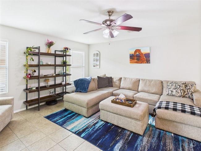 Living area with tile patterned flooring and ceiling fan | Image 5
