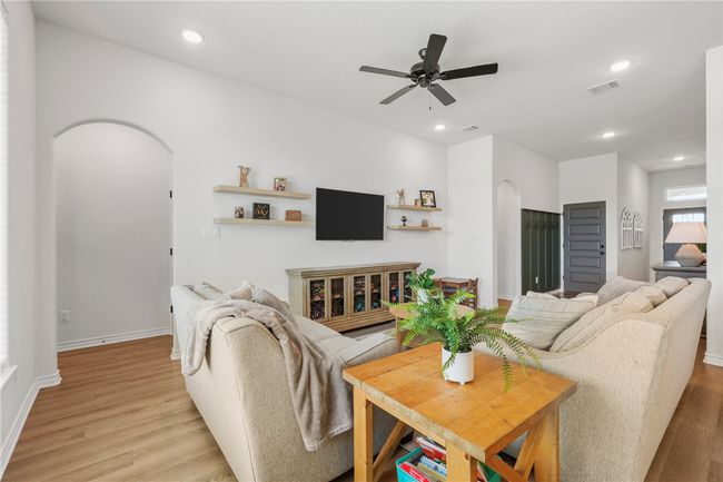 Living room featuring arched walkways, light wood-style flooring, ceiling fan, and recessed lighting | Image 13