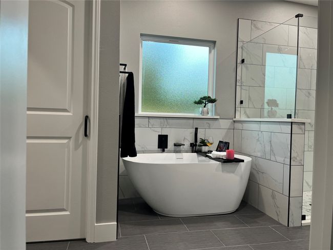 Bathroom with a freestanding bath, walk in shower, and tile patterned flooring | Image 24