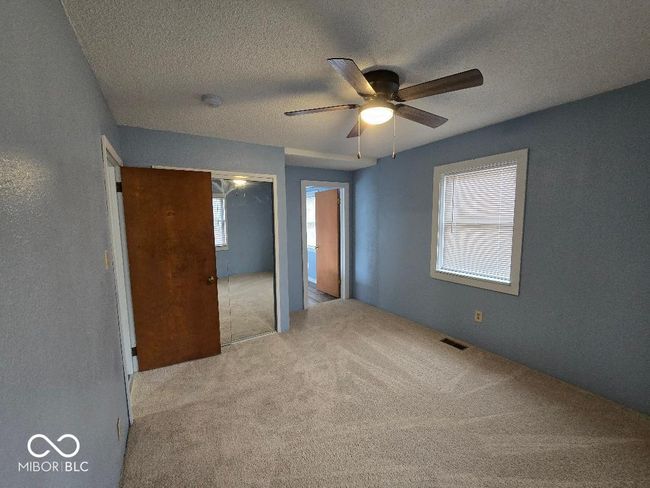 unfurnished bedroom featuring visible vents, ceiling fan, carpet, a closet, and a textured ceiling | Image 27