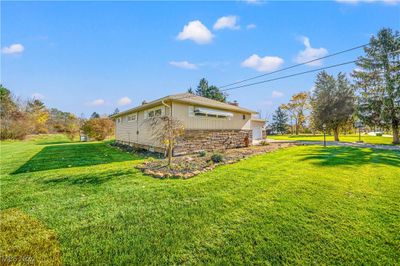 View of property exterior featuring a beautiful expansive lawn. | Image 3