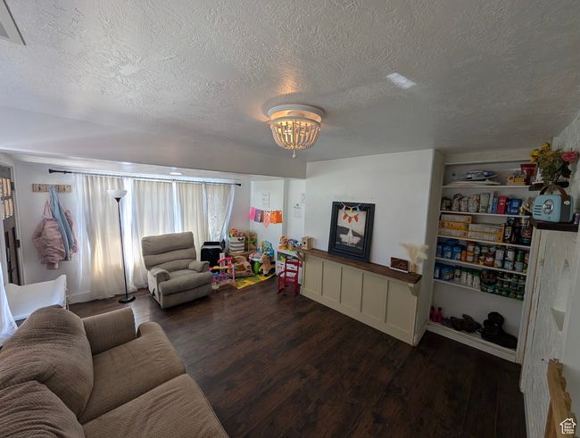 Living room featuring a chandelier, a textured ceiling, and wood finished floors | Image 13