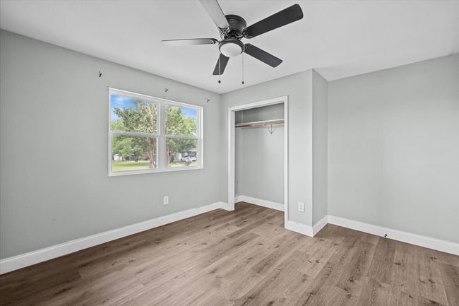 Unfurnished bedroom with baseboards, wood finished floors, a closet, and ceiling fan | Image 14
