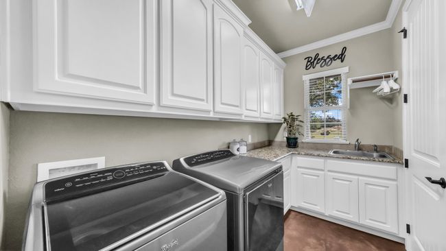 Laundry area with washing machine and clothes dryer, cabinet space, and crown molding | Image 35