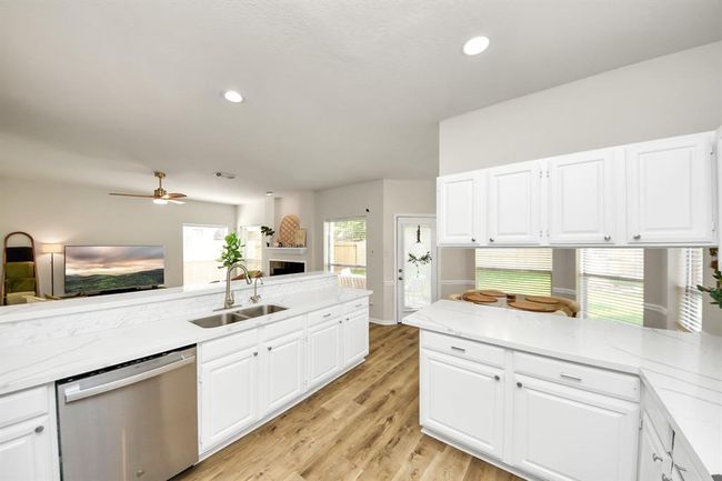 With plenty of natural light and soft recessed lighting, this kitchen feels open and fresh. The quartz countertops and stainless steel appliances make cooking here both stylish and simple. | Image 19