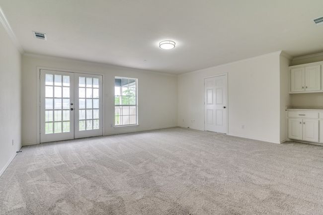 Empty room featuring ornamental molding, light carpet, french doors, and baseboards | Image 21