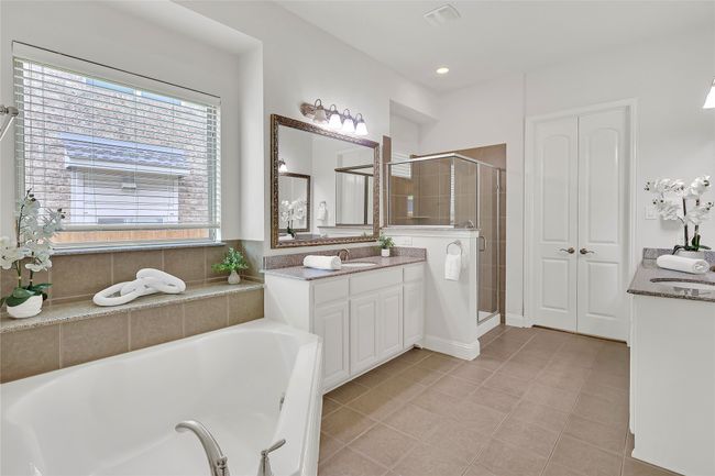 Bathroom featuring vanity, a garden tub, a shower stall, and tile patterned floors | Image 17