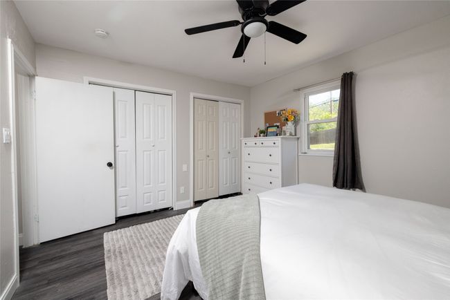 Bedroom featuring dark wood-style flooring, a ceiling fan, and multiple closets | Image 26